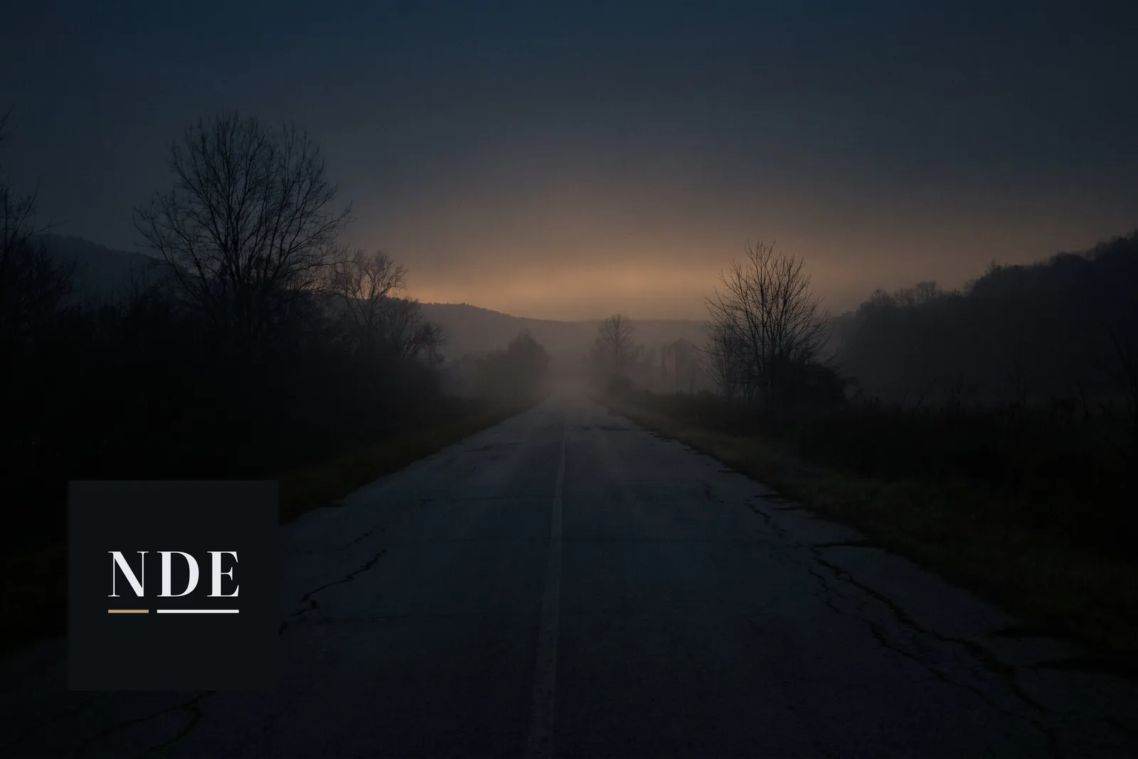 An empty road at dusk with mist over the fields, from the project's home page