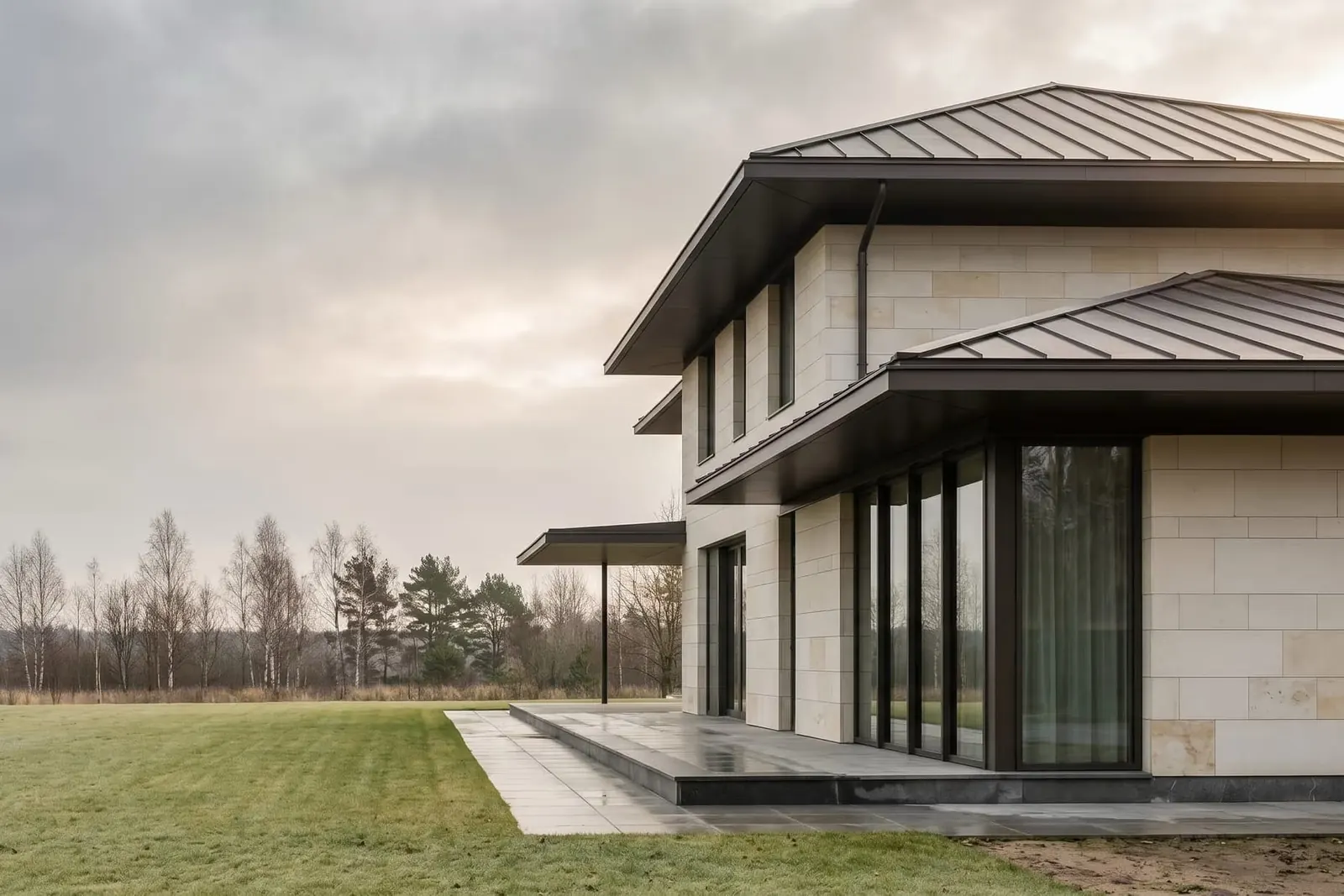 A pale stone house with floor-to-ceiling windows and a metal roof, a What Else project